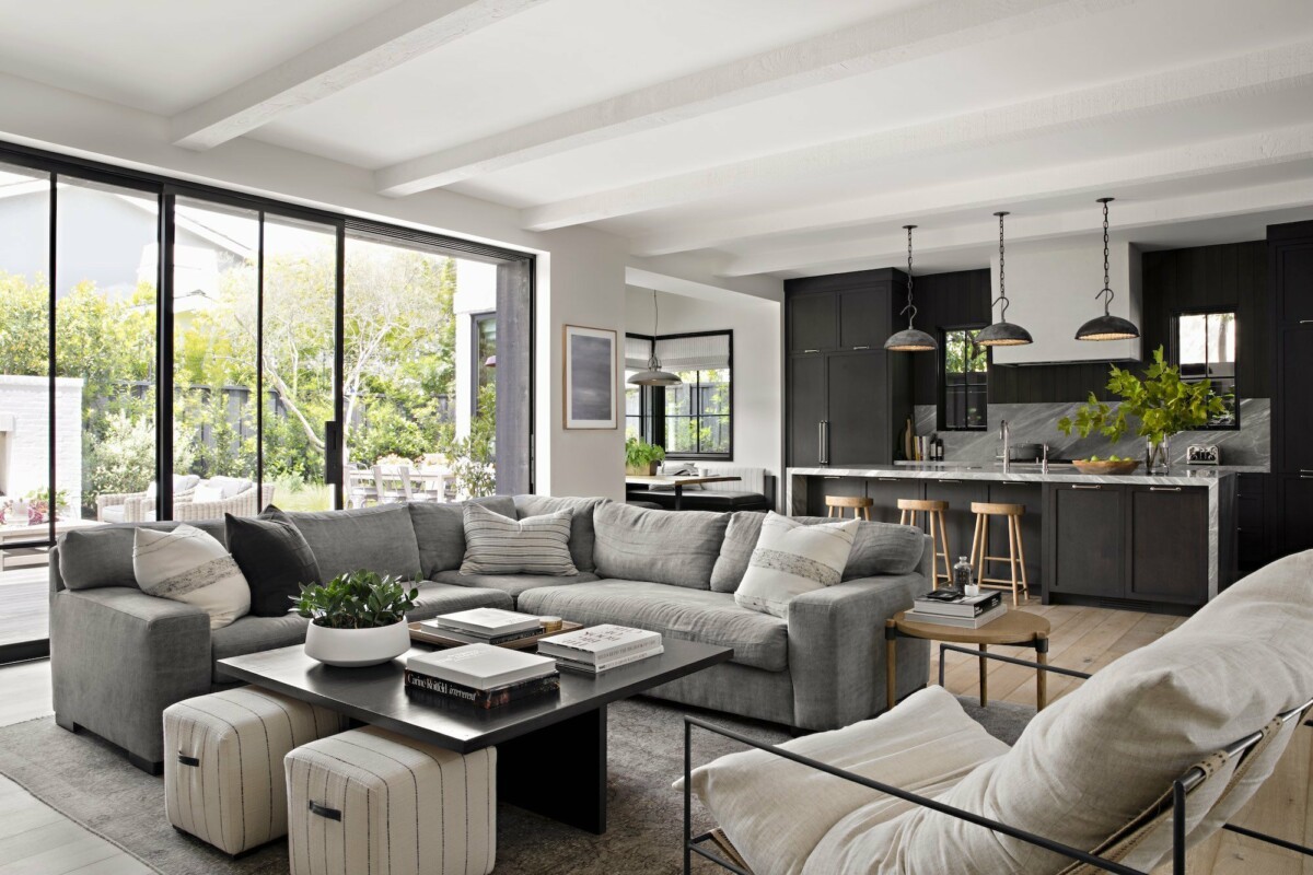wicker patio furniture surf-inspired décor sliding glass doors outdoor fireplace open floor plan Newport Beach moody color scheme interiores abiertos interactive rooms industrial details gray sectional sofa estilo californiano decoración moderna decoración americana coastal décor charcoal gray decor california brass accessories backyard decor 