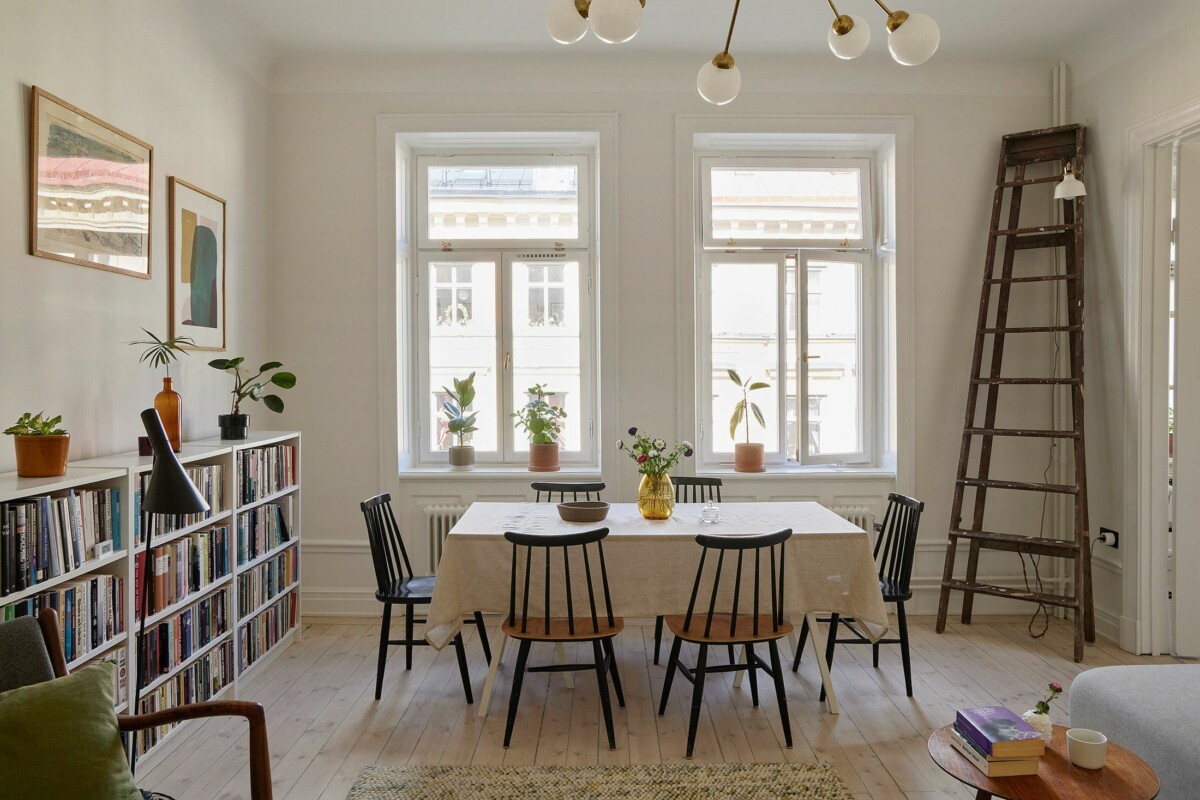 warm decoration vintage furniture vintage stockholm south-facing balcony renovated renovado preserved antique elements planta diáfana abierta open floor plan muebles vintage libros estufa de azulejos Estocolmo elementos antiguos conservados decoración cálida bright penthouse books balcón orientación sur ático luminoso altura al techo 