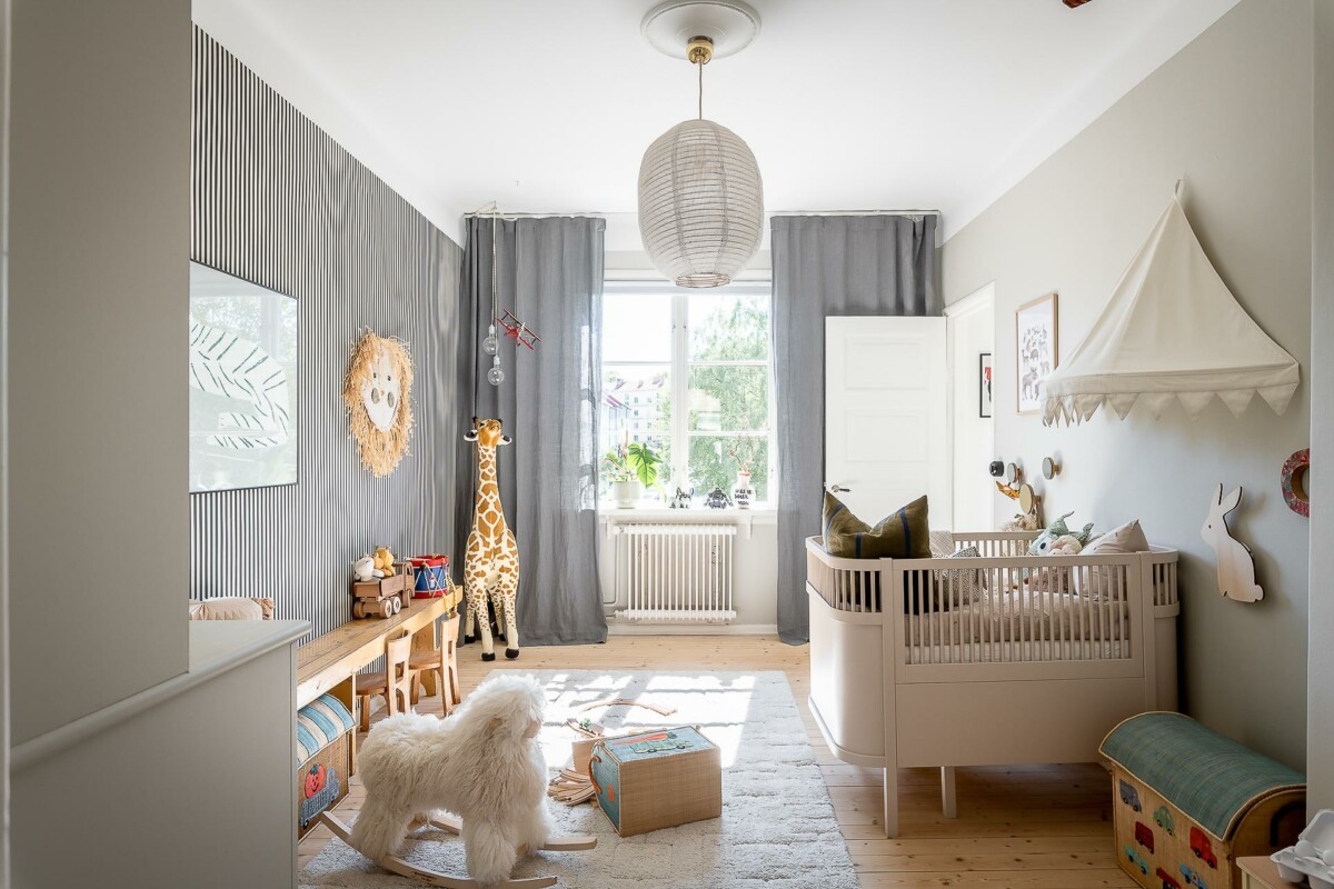 zona de juegos wooden table bench wooden floor suelo de madera striped wallpaper soft toys play area peluches papel de pared rayas kid´s room iluminación natural dormitorio infantil cuna crib Children's bedroom carpet banco de madera mesa alfombra 