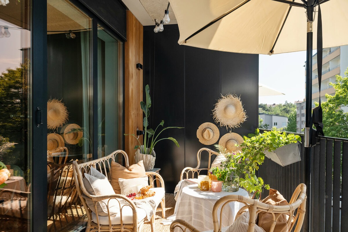 zona de sofá y sillones tipi para juegos suelo de madera sombrilla beige sombreros de paja plantas paredes negras olorosas muebles de mimbre macetas en macramé Inspiración boho habitaciones infantiles optimizadas frutales estilo escandinavo estética en negro y natural balcón relajado balcón con espacio para BBQ 
