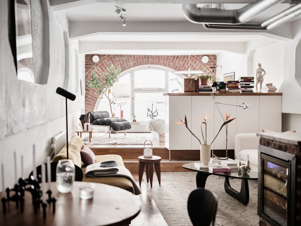 vigas expuestas ventanal en arco tuberías metálicas planta diáfana medio muro divisorio loft ladrillo visto estudio industrial estilo urbano escandinavo estilo industrial dormitorio en nivel más alto diseño de interiores decoración de interiores conductos metálicos en el techo 45 m² 