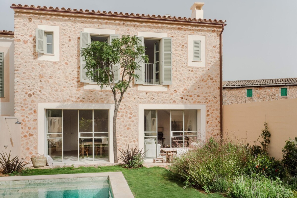Inspiración mediterránea: Casa adosada con fachada de piedra y contraventanas color menta en Mallorca
