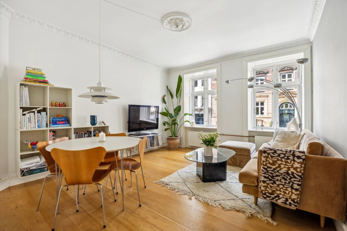 Vivienda típica danesa Techos altos con molduras suelos de madera Salón comedor iluminado Renovado con estilo Paleta de colores suaves muebles de diseño danés estilo nórdico Estilo de vida escandinavo Estilo de vida danés Espacio acogedor y funcional diseño contemporáneo decoración escandinava Decoración de interiores danesa cocina cerrada apartamento renovado Apartamento en Copenhague 