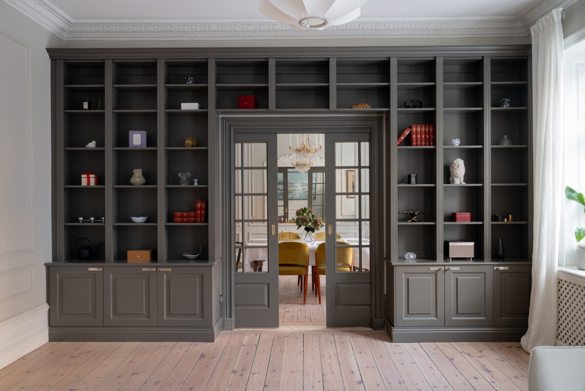 salón nórdico puertas correderas objetos decorativos madera librerías oscuras interiorismo iluminación hogar gris oscuro estilo escandinavo diseño decoración a medida 
